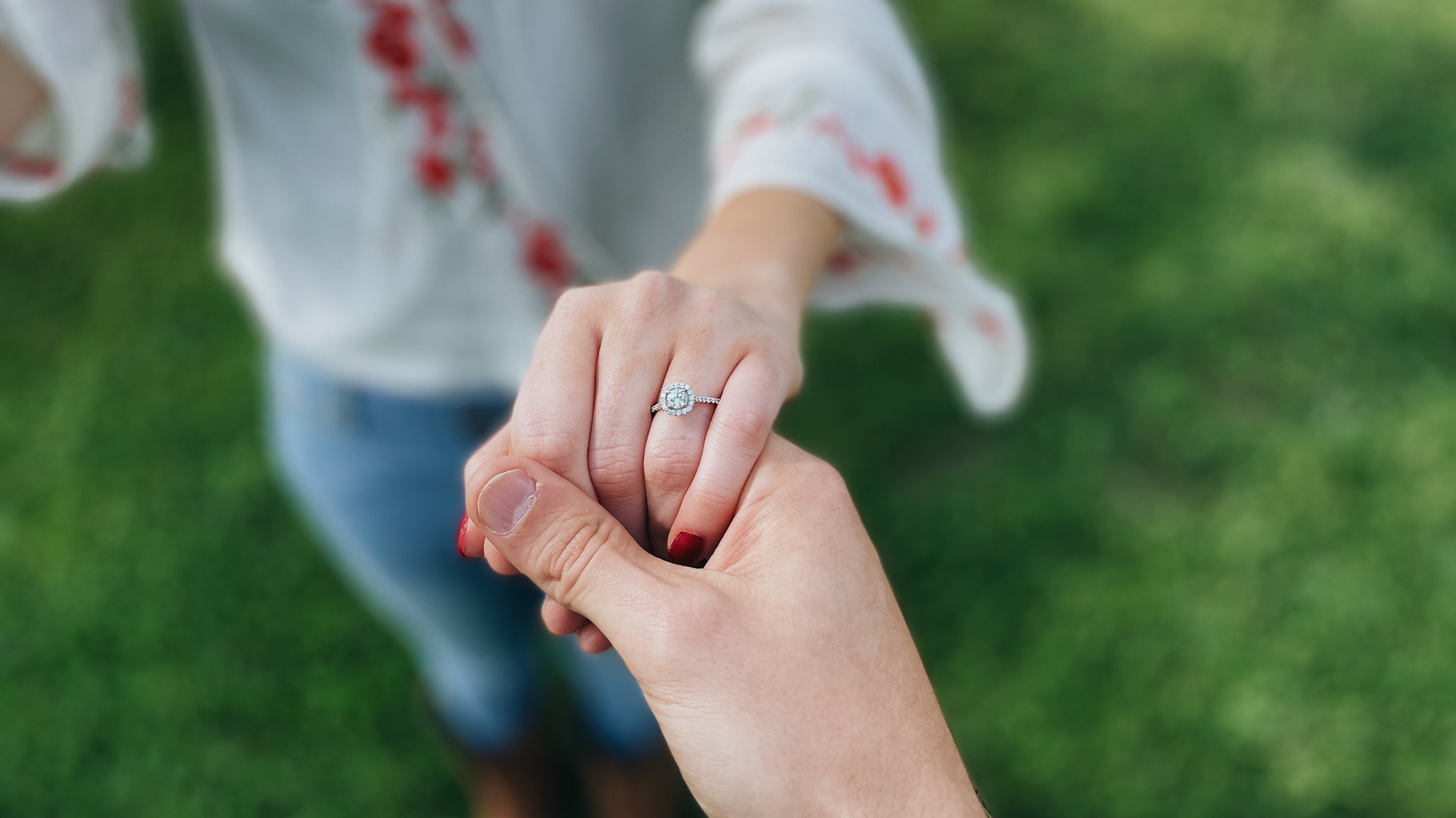 a person showing off her engagement ring to the camera
